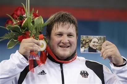 德国选手马蒂亚斯施泰纳在领奖台上手持金牌,鲜花和妻子的照片