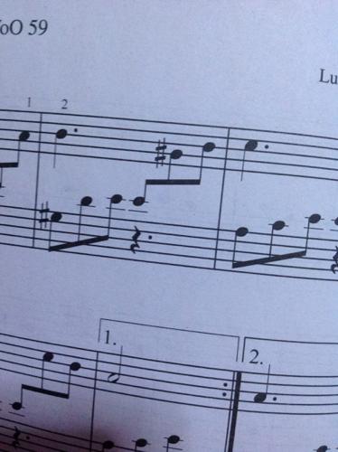 这种情况钢琴谱上,把音画在低音谱上,而下面又画着休止符,应该用左手