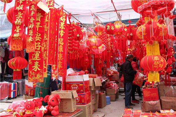 批发市场,在一喜庆用品店看到,30余平方米的店铺内挤了近10位挑选春联