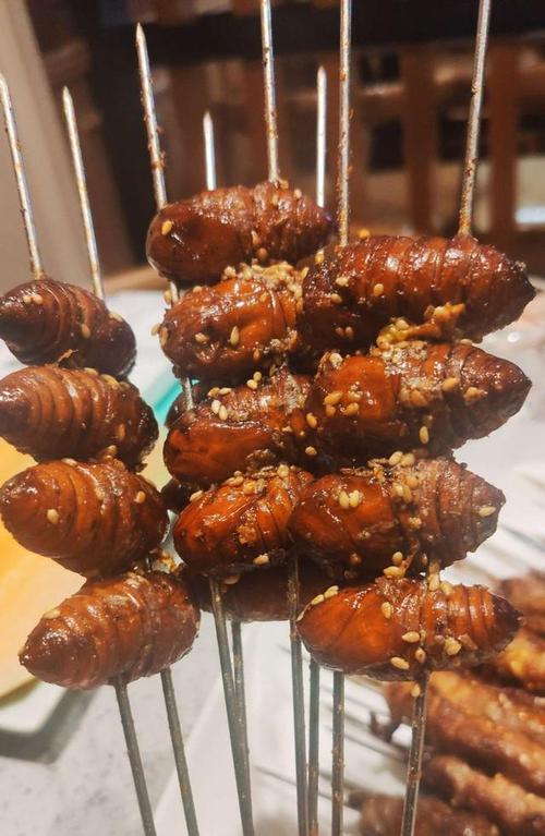 烤蚕蛹,咬开的时候有爆浆感,外壳嚼起来有点硬,新鲜好吃,里面满满的