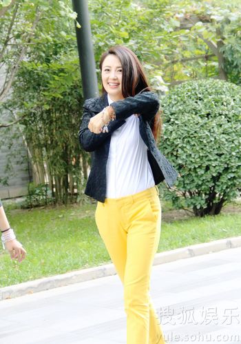 杨童舒裤装出行长腿抢眼 不拘小节当街整衣