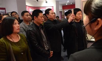 4月1日,燕振昌事迹展馆,颜永江边听讲解边用手机拍摄展馆资料.