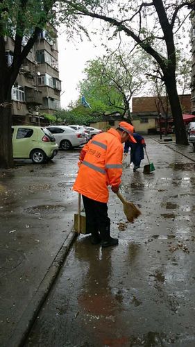 社区工作人员和保洁人员清扫辖区卫生
