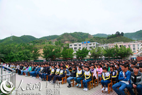 017年高考开考后,广西凤山县高级中学校长罗凤章跟县长在一起.
