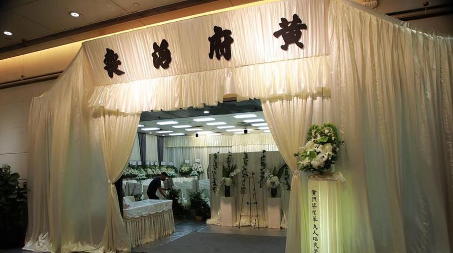 现场用白色的纱搭起灵棚,上面写着"黄府治丧"四个字,里面四周陈列花圈