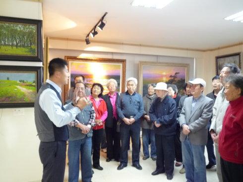 馆长胡耀中向民进老会员详细而专业地介绍朝鲜绘画艺术的渊源及特点
