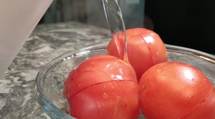 西红柿表面切十字花刀,用开水烫一下,西红柿去皮后切成块