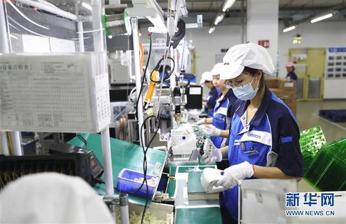 欧姆龙(大连)有限公司工人在车间工作(3月21日摄).