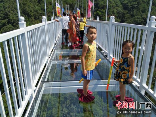 10月1日,游客行走在桂林逍遥湖景区5d全透明玻璃桥上观光游览.