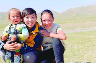 记者周雪梅在内蒙古与当地儿童一起合影.