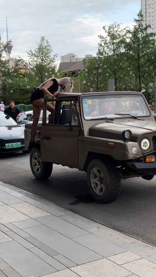 街拍网红美女偶遇网红二狗开敞篷小吉普带两个大长腿女神兜风大长腿上