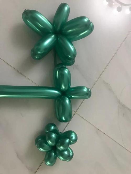2,长条桌面圣诞气球 用金属绿色长条气球,做个双层五个花瓣的花,从小