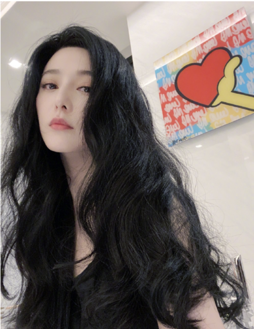 照片中她穿着黑色吊带上衣,秀出纤细锁骨. 头发盘起来时露出天鹅颈.