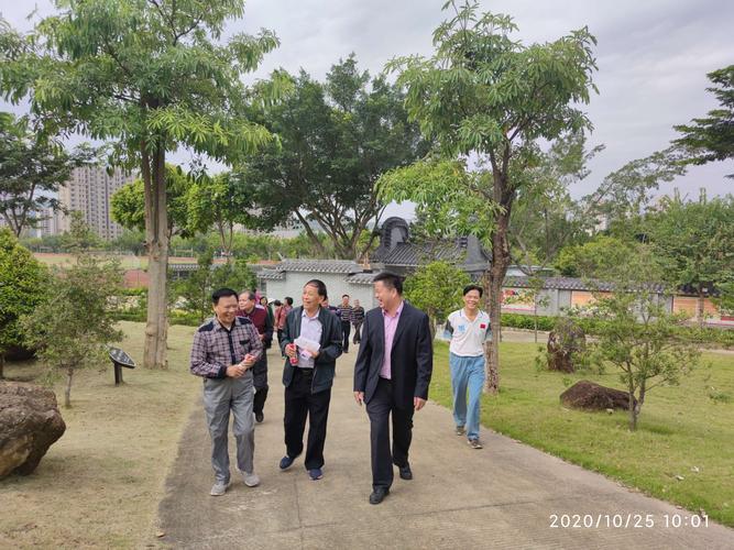 梁爱平局长带着老同志边走边告诉老同志明园里边的风景.