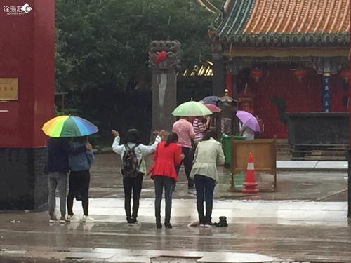 冒雨拜佛的年轻人.