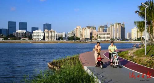 市民带着孩子在红城湖公园的步道上散步.
