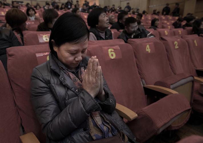邢明霞在分房摇号现场祈祷能抽个好签