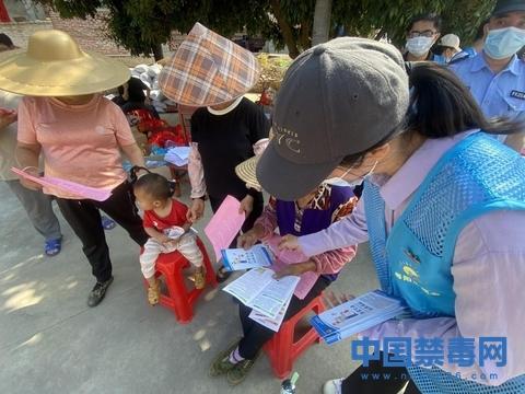 图为禁毒社工向群众发放禁毒宣传单.中国禁毒网发