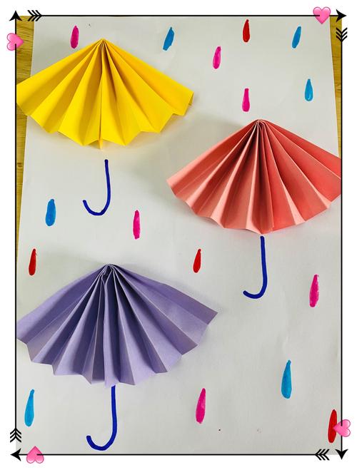 最后,用彩笔装饰伞柄和雨滴,漂亮的小伞就制作完成啦