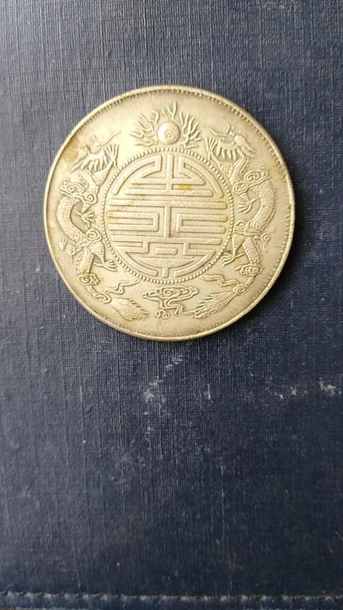双龙寿字币求鉴定.为什么照片是有点黄色呀
