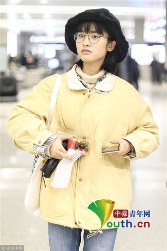 2018年1月30日,上海,沈月亮相机场,她身穿黄色外套搭配渔夫帽十分小