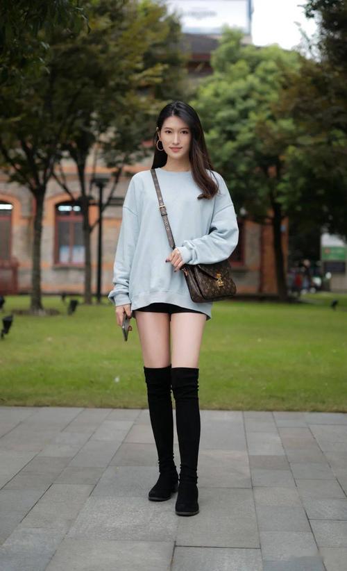 冰蓝色宽松卫衣,搭配黑色短裤,用过膝长靴来加持再合适不过了.