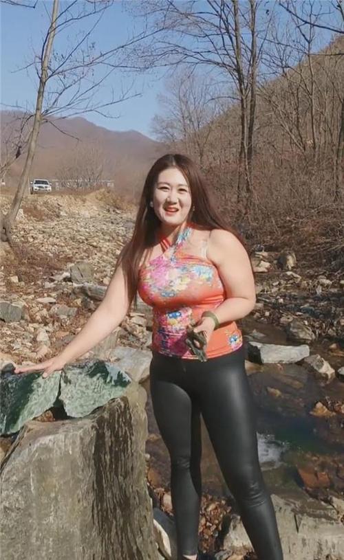身材胖嘟嘟的东北大姐花色吊带衫搭配紧身皮裤性感十足