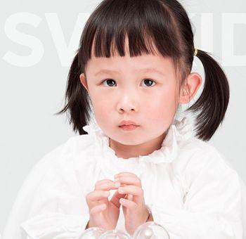 圆脸小女孩乌黑的直发短而少,梳理成齐刘海齐肩波波头发型,小女孩的