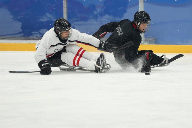 3月1日,中国残奥冰球队球员白雪松(左)在训练中.新华社记者 马希平 摄