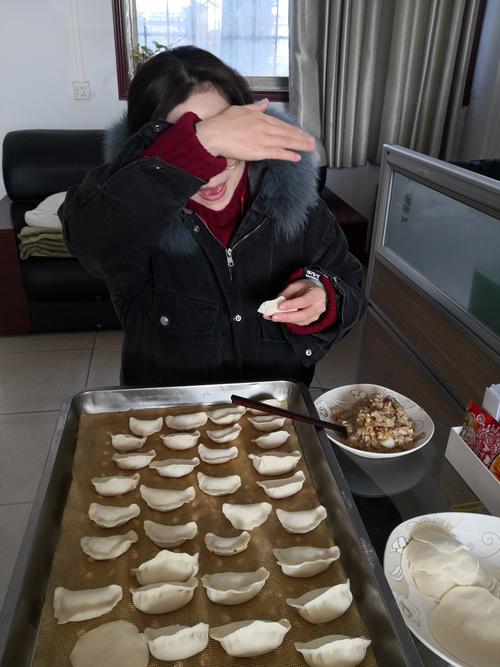 瞧,这位美女害羞的挡住了她美丽脸庞,却挡不住饺子盘里面整齐划一