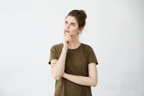 年轻迷人的女孩,用手托住下巴到距离眺望白色背景思考