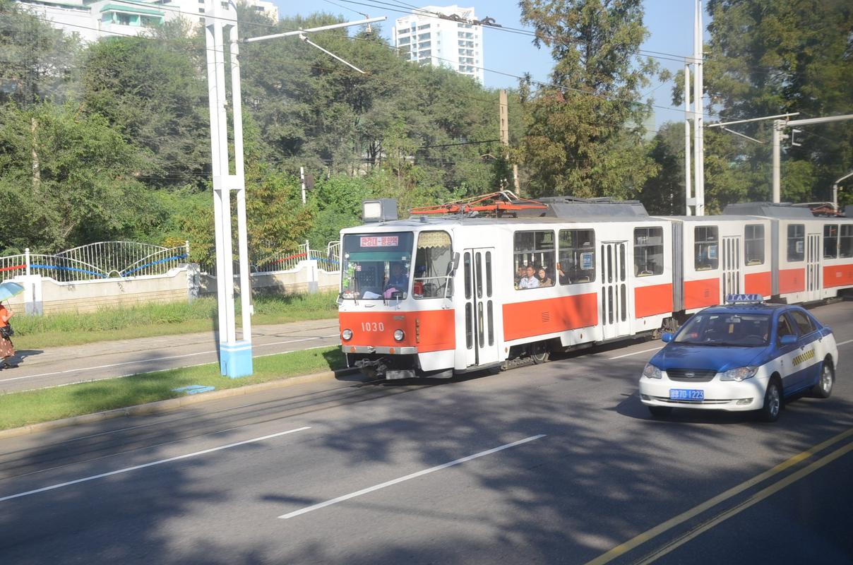 图为朝鲜平壤的有轨公交车和出租车,平壤百姓搭乘公交的很多,搭乘出租