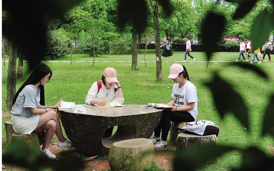 浙师大校园里,三名女大学生正在户外阅读.