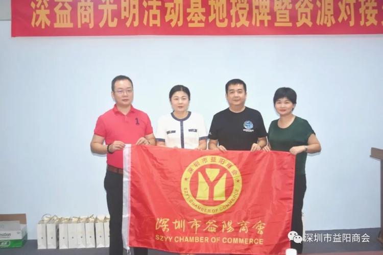 执行会长李德新(右二),刘胜男(左二)向光明联络站站长龚频(左),联络