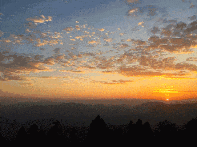 庭院西望,太阳正一点一点落入山的另一侧,上方浮漾着一层青一层粉一层