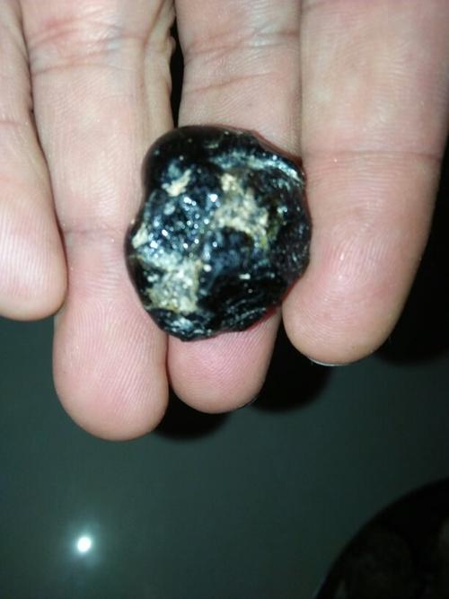 懂得玩钻石或陨石的高手,帮我看这是黑钻石还是玻璃陨石?谢谢!