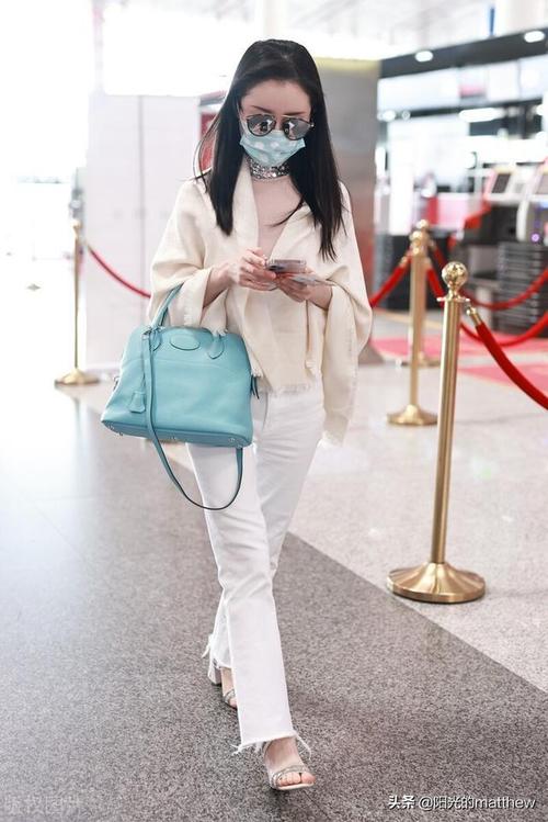 街拍:舒畅头戴墨镜身着白色披肩白色长裤手提蓝色小包