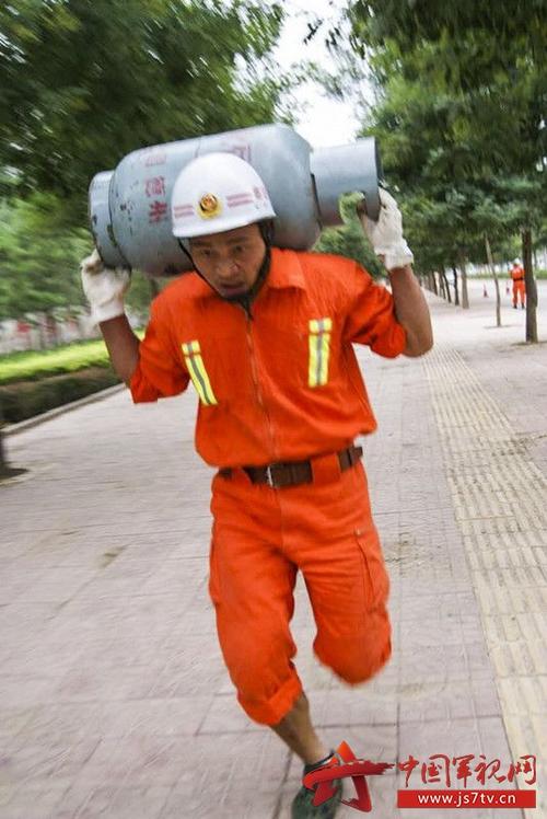 图为高明涛日常训练,扛着煤气罐奔跑,争分夺秒.