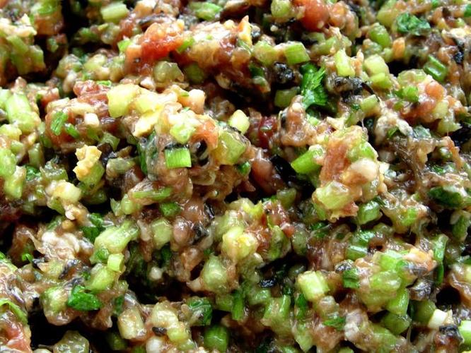 将芹菜放入调拌好的肉馅中,顺时针搅拌,做成馅心.