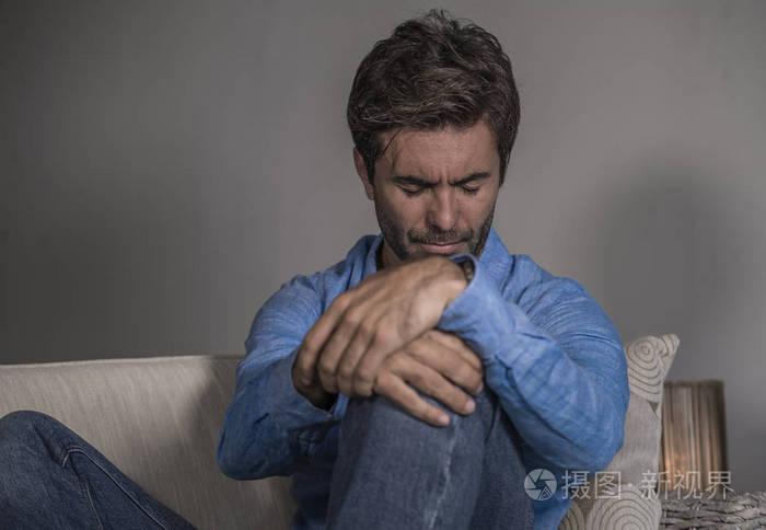 生活方式肖像年轻,有魅力,英俊,悲伤的拉丁男人,疲惫和沮丧地坐在家里