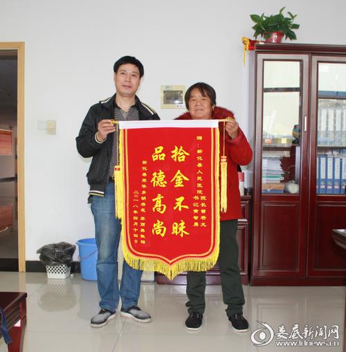 (胡秀花老人把锦旗送到医院办公室工作人员手中)