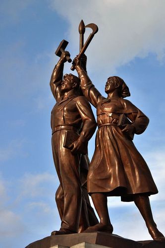 工人,农民和知识分子高擎党徽的塑像.