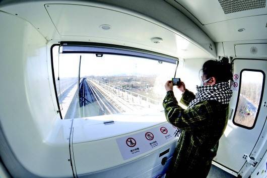 12月26日,乘客在北京地铁燕房线无人驾驶地铁列车内拍照.