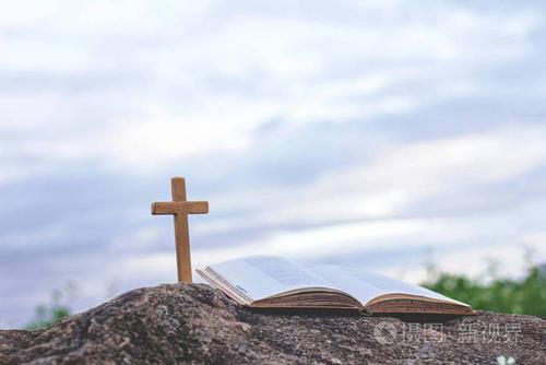 十字架和圣经在岩石上.崇拜, 罪孽和祷告