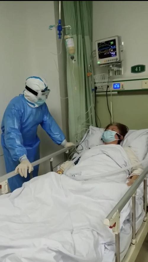 范学朋在武汉市第一医院隔离病房内查房与患者交流