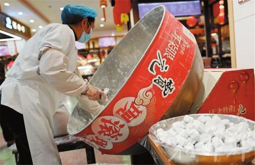 光明大街美食林商场的员工正在现场手工制作元宵,喜迎传统佳节