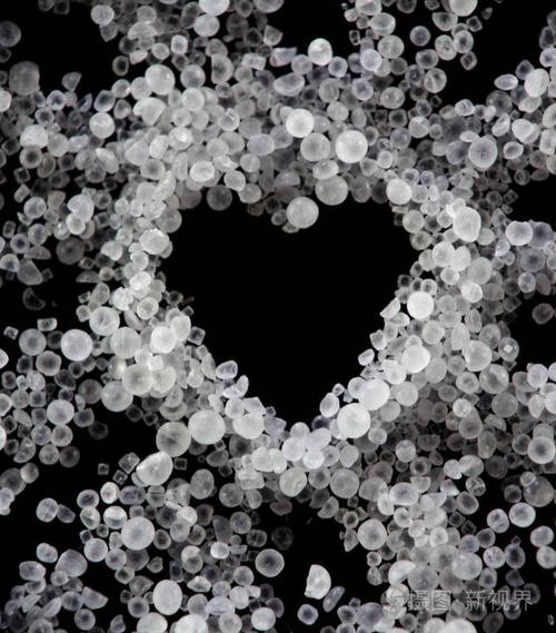 黑暗的心白色透明的盐晶体在黑暗的背景下