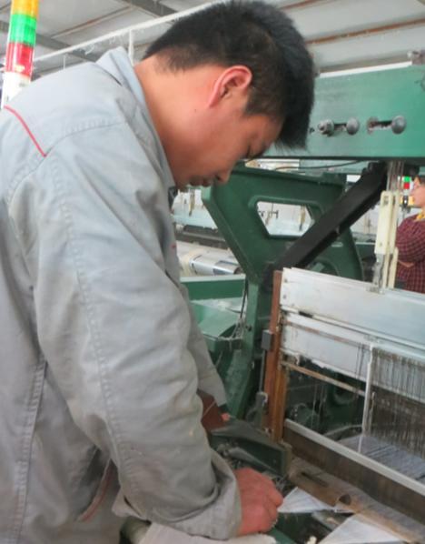 工厂的工人在修理织布机