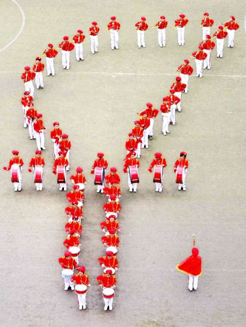 安居区东禅镇中心小学校少先队员摆出"火炬"队形比赛鼓号