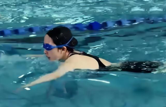 杨幂游泳时的造型格外的专业,她穿着一件黑色的泳衣,佩戴了一顶黑色的